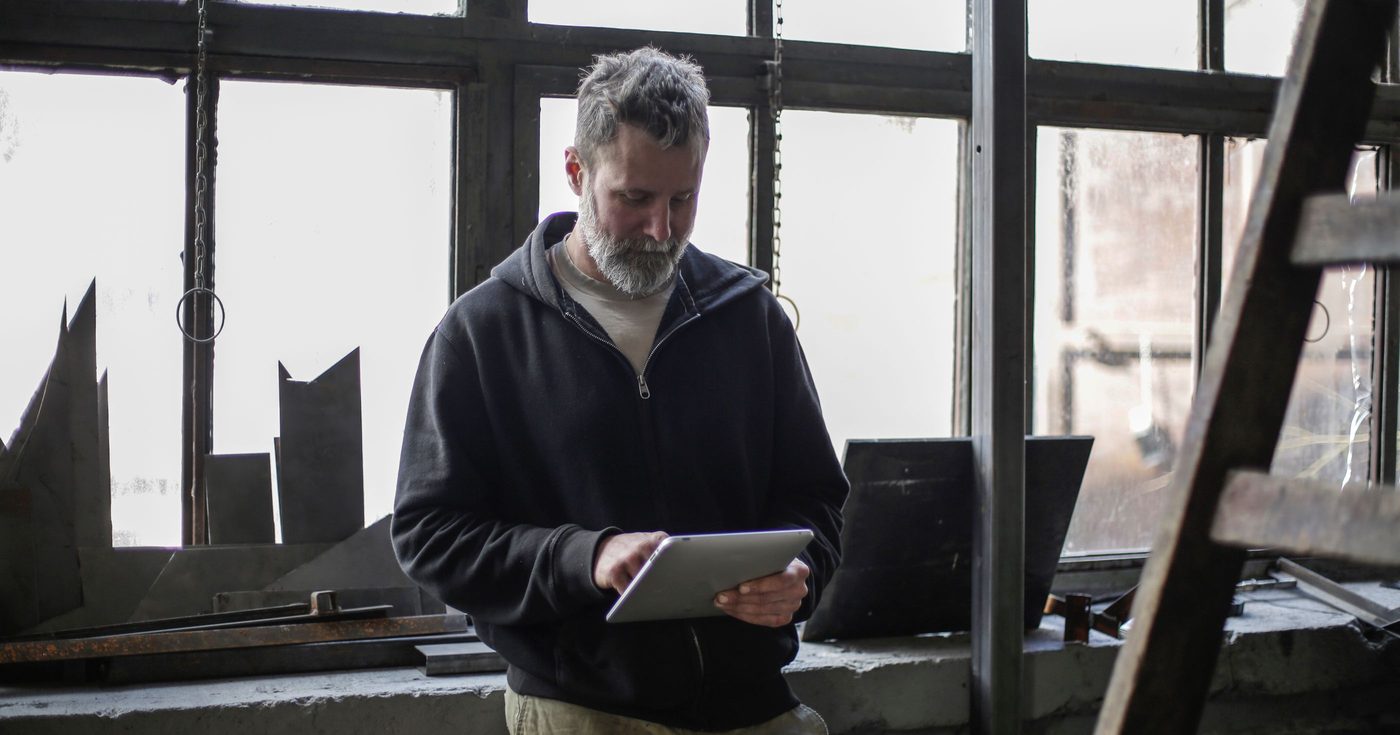 Ein Handwerker mit einem Tablet in seiner Werkstatt