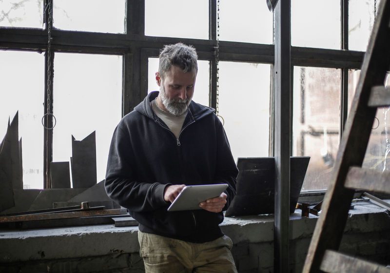 Ein Handwerker mit einem Tablet in seiner Werkstatt